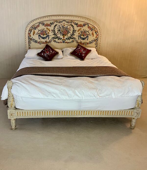 A king size polychrome and parcel gilt bed