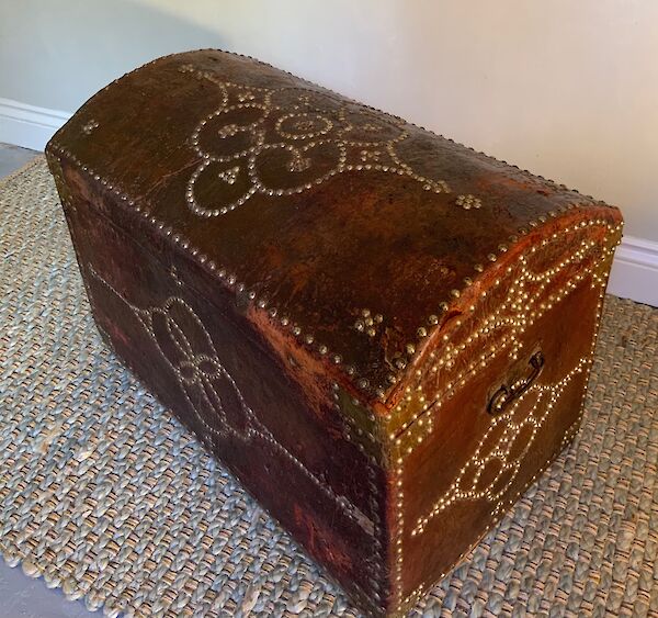 A burgundy leather covered travelling trunk